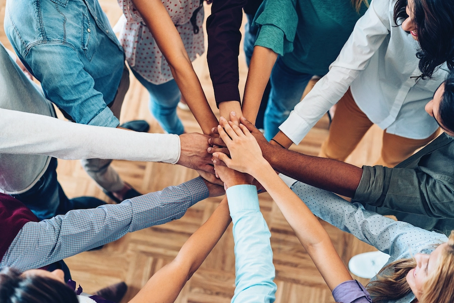 Hands together in the middle of a circle