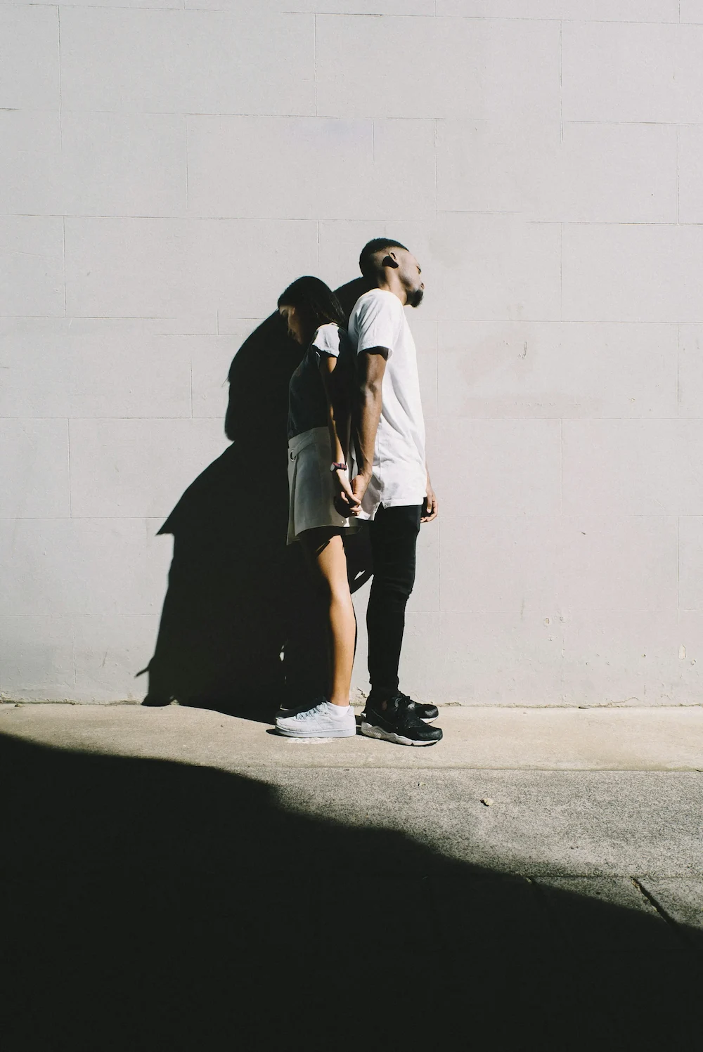 Couple holding hands facing away from each other